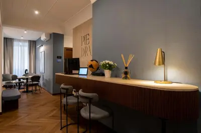 a lobby with a bar with stools and a table at Boutique Hotel Piedra Rome City Centre in Rome