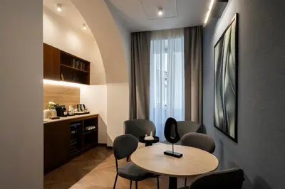 a room with a table and chairs and a kitchen at Boutique Hotel Piedra Rome City Centre in Rome