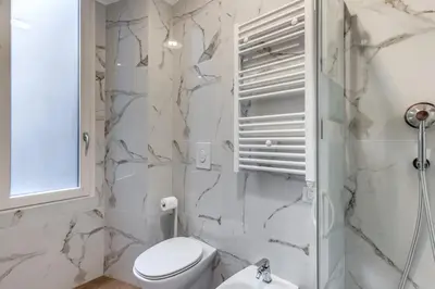 a white bathroom with a toilet and a shower at Orazio's Charming Apartment in Rome