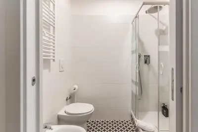 a white bathroom with a toilet and a shower at Orazio's Charming Apartment in Rome