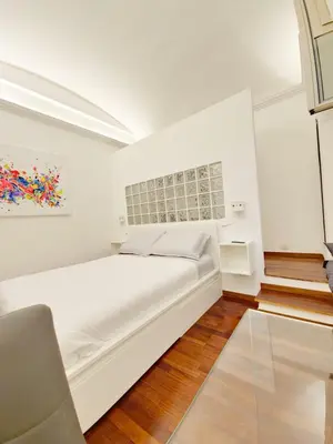 a white bedroom with a bed and a painting at Like at Home Trastevere in Rome