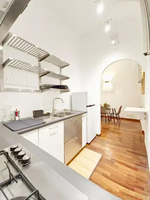 a kitchen with white cabinets and a wooden floor at Like at Home Trastevere in Rome