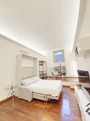 a bedroom with a large white bed and a table at Like at Home Trastevere in Rome