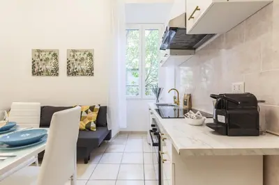 a kitchen and a living room with a couch at Hostly-Michelangelo Cloister Suite-Center of Rome in Rome