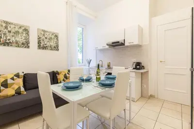 a kitchen and living room with a white table and chairs at Hostly-Michelangelo Cloister Suite-Center of Rome in Rome