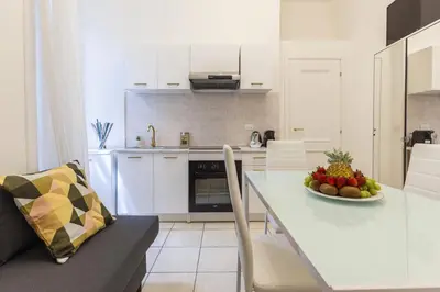 a kitchen with a table with a bowl of fruit on it at Hostly-Michelangelo Cloister Suite-Center of Rome in Rome