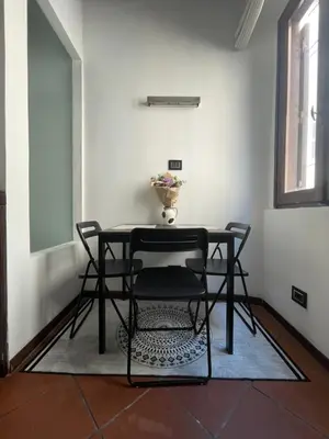 a black table and chairs in a room with a window at A Den for Two in Rome