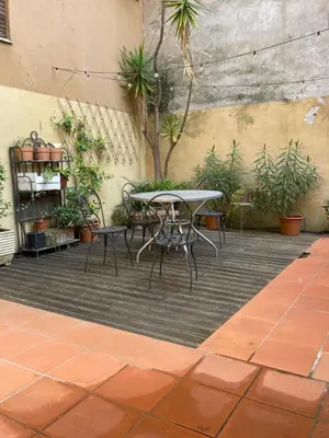 a patio with a table and chairs and plants at A Den for Two in Rome
