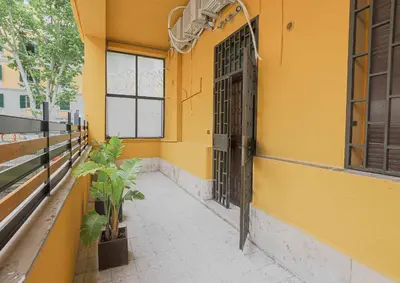 a yellow building with a door and a potted plant at Aquas Salvias in Rome