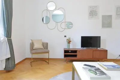 a living room with a chair and a television at YCH-Comfortable 2 bedrooms flat near Colosseum in Rome