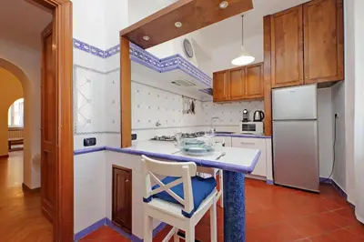 a kitchen with a counter and a white refrigerator at YCH-Comfortable 2 bedrooms flat near Colosseum in Rome