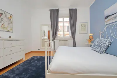 a bedroom with a white bed and a blue rug at YCH-Comfortable 2 bedrooms flat near Colosseum in Rome