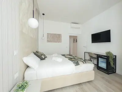 a white bedroom with a bed and a desk at White Ottaviano in Rome