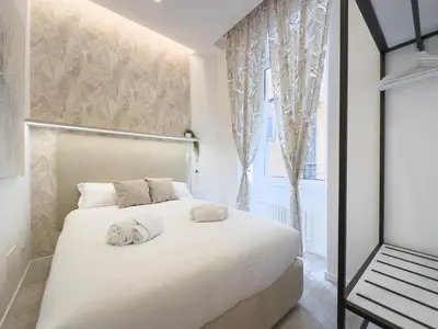 a white bedroom with a bed and a window at White Ottaviano in Rome