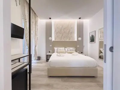 a white bedroom with a bed and a table at White Ottaviano in Rome
