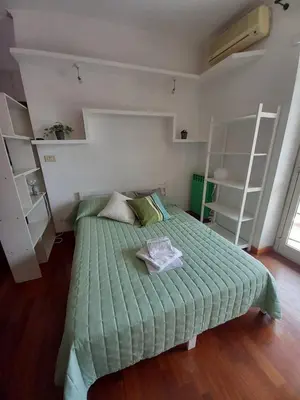 a bedroom with a bed with a green comforter at La mia casetta a Porta Furba in Rome