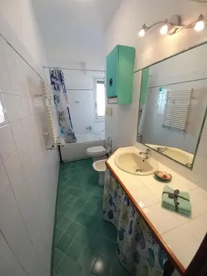 a bathroom with a sink and a toilet and a mirror at La mia casetta a Porta Furba in Rome