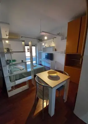 a room with a small table and a kitchen with a room at La mia casetta a Porta Furba in Rome