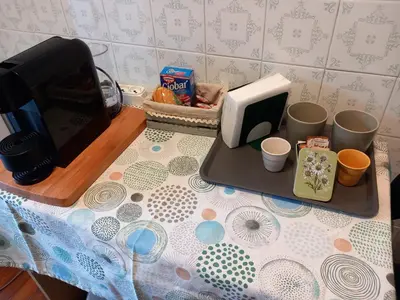a kitchen counter with a microwave and cups on a table at La mia casetta a Porta Furba in Rome