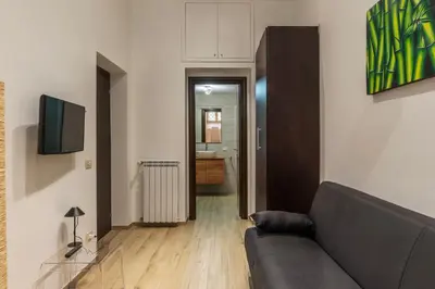 a living room with a couch and a television at GuestHost - Trastevere Three Cozy Rooms in Rome