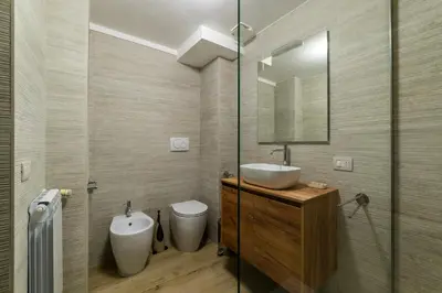 a bathroom with a sink and a toilet and a mirror at GuestHost - Trastevere Three Cozy Rooms in Rome