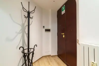 a hallway with a door and a statue in front of it at GuestHost - Trastevere Three Cozy Rooms in Rome