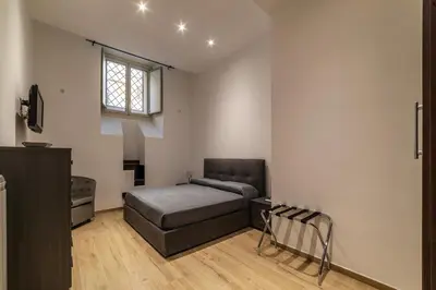 a bedroom with a bed and a chair in it at GuestHost - Trastevere Three Cozy Rooms in Rome