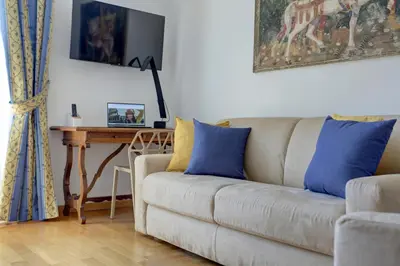 a living room with a couch with blue and yellow pillows at Colosseo Family Art 3BDR - Home and More in Rome