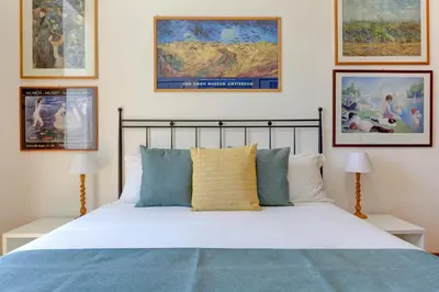 a bedroom with a bed and some pictures on the wall at Colosseo Family Art 3BDR - Home and More in Rome