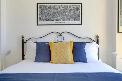 a bedroom with a bed with blue and yellow pillows at Colosseo Family Art 3BDR - Home and More in Rome