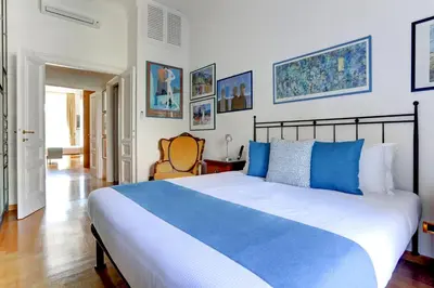 a bedroom with a large bed with blue pillows at Colosseo Family Art 3BDR - Home and More in Rome