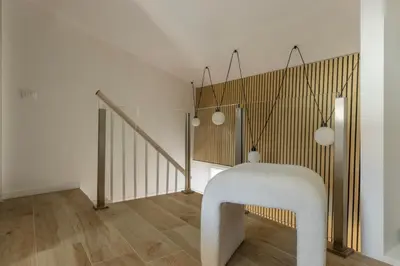 a hallway with a staircase with white walls and wood floors at MauveSweetRhome 2 in Rome