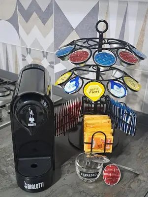 a counter top with a black appliance with stickers on it at Amores Roma Apartment in Rome