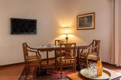 a dining room with a table and chairs and a television at Roma Centro Storico Luxury - Piazza di Spagna in Rome