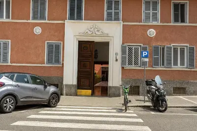 a motorcycle parked in a parking lot in front of a building at S&M Guest Home - San Giovanni in Rome