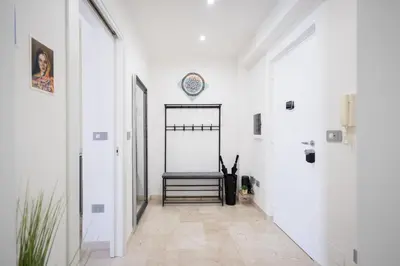 a hallway with a chair and a clock on the wall at Marconi white flower house in Rome