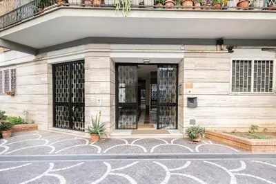 an entrance to a building with potted plants at Marconi white flower house in Rome