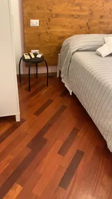 a bedroom with a bed and a table on a wooden floor at Domus Filiberto by Local Domus in Rome