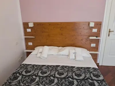 a bed with white pillows and a wooden headboard at Domus Filiberto by Local Domus in Rome