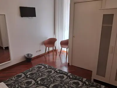 a room with a bed and two chairs and a television at Domus Filiberto by Local Domus in Rome