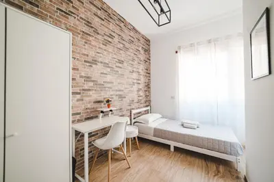a bedroom with a brick wall and a bed and a desk at Tibur Domus B&B in Rome