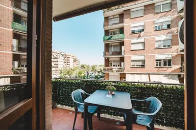 a balcony with a table and chairs and a building at Tibur Domus B&B in Rome