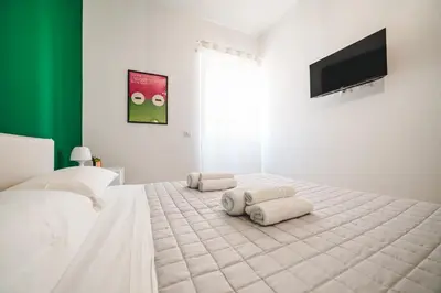 a bedroom with a large white bed with towels on it at Tibur Domus B&B in Rome
