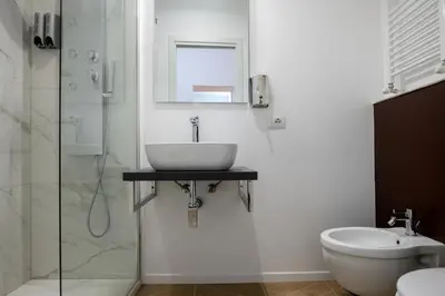 a bathroom with a sink and a toilet and a mirror at Vatican 23 Museum Suites in Rome