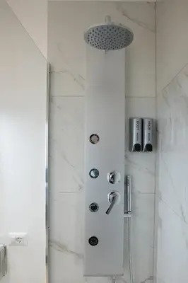 a shower in a bathroom with white marble walls at Vatican 23 Museum Suites in Rome