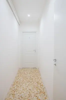 an empty room with a white door and a rug at Vatican 23 Museum Suites in Rome