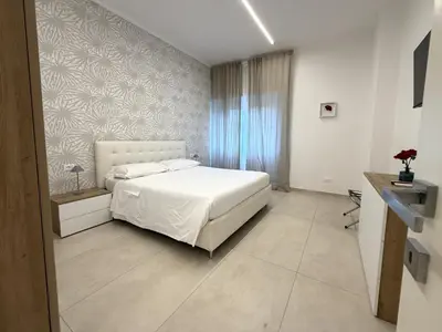 a bedroom with a white bed and a wall at Modern Home Trastevere in Rome