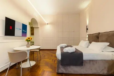 a hotel room with a bed and a table and chairs at Augusto Imperatore Suite in Rome