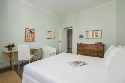 a bedroom with a white bed and a desk at Vatican Zen House - Cale 05 in Rome