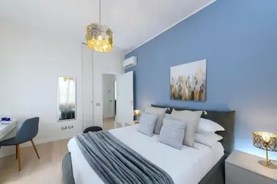 a bedroom with a large white bed and a desk at San Pietro Nausicaa Penthouse in Rome